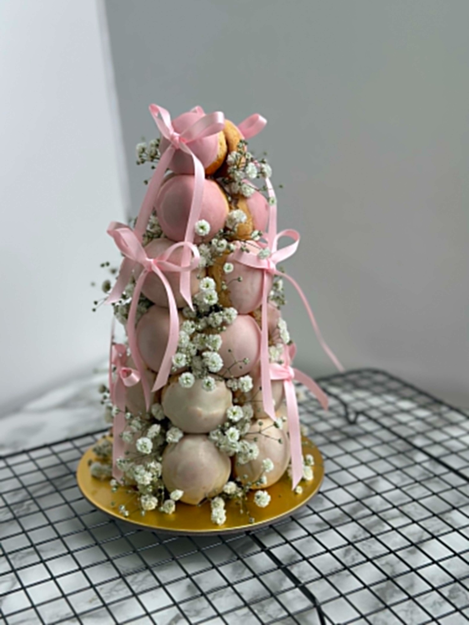 Romantic pink croquembouche with ribbons and flowers